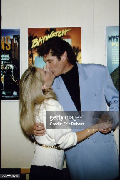 Acteur américain David Hasselhoff et sa femme Pamela Bach s'embrasse devant une affiche de la série "Baywatch".
