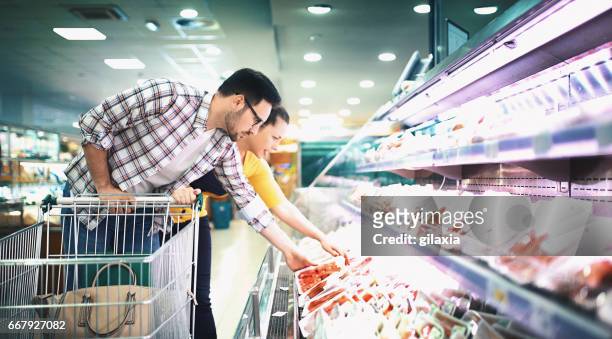 lebensmittel im supermarkt kaufen - couple in supermarket stock-fotos und bilder