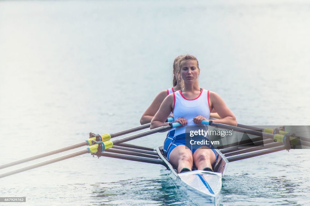 Two women rowing on a lake