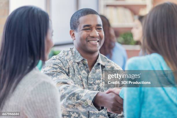 sonriendo el reclutador militar saluda a los estudiantes en el evento de reclutamiento - military recruitment fotografías e imágenes de stock
