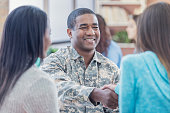Smiling military recruiter greets students at recruitment event