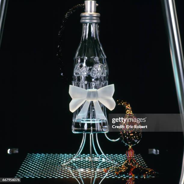 French fashion designer Olivier Lapidus designed this crystal perfume atomizer shaped like a Coca-Cola bottle. French embroiderer Francois Lesage...