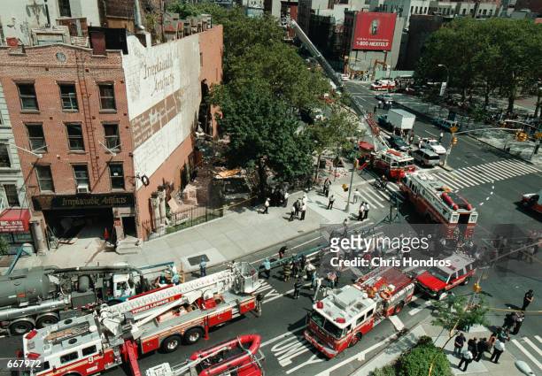 Emergency vehicles gather around an apartment building that partially collapsed July 13, 2000 in New York, injuring at least ten people who were...