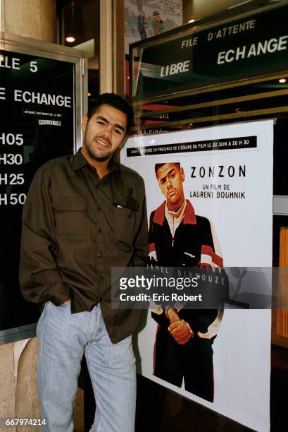 French-born Moroccan actor Jamel Debbouze stands next to a poster advertising his 1998 movie, Zonzon.