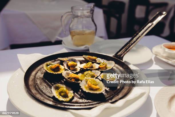 limpets on the frying pan - iron wine stock pictures, royalty-free photos & images
