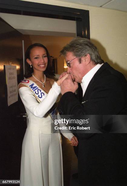 Actor Alain Delon kisses the hand of Sonia Rolland, who won Miss France 2000.