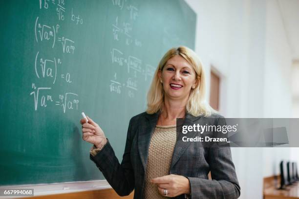 senior math professor in lecture hall near the blackboard with formulas - mathematician stock pictures, royalty-free photos & images