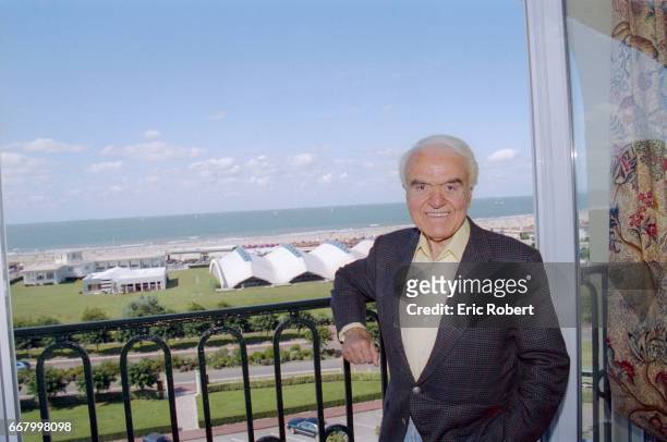 Jack Valenti, President of the Motion Picture Association of America, stands near a window overlooking the sea in Deauville, France. He is attending...