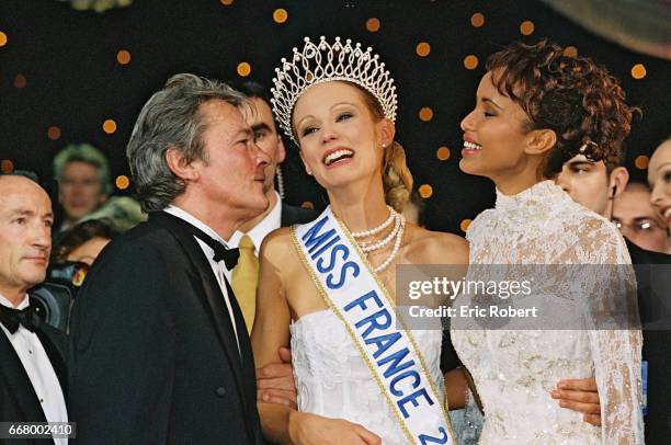 Elodie Gossuin on the arm of Alain Delon, jury president, and Sonia Rolland, Miss France 2000.