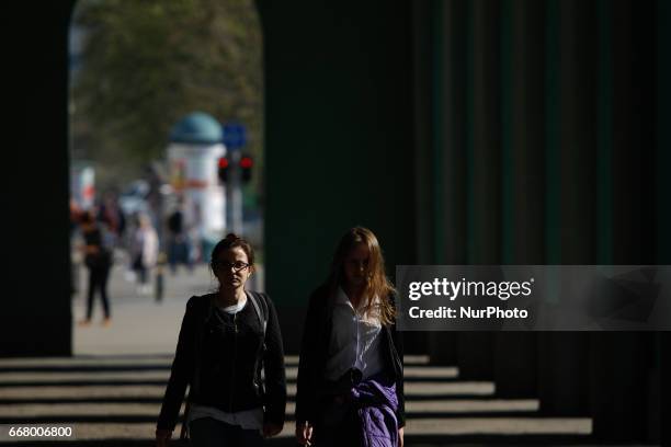 Young women are seen walking through a passageway in the center of Warsaw on 11 April, 2017.