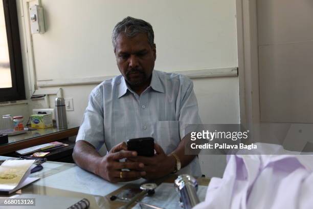 Physician Hemant Haldavnekar examines a tele ECG received on his mobile phone on March 4, 2017 in Mumbai, India. A credit card sized life-saving...
