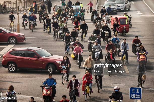 Chinese commuters ride bike shares and other modes of transport in the bicycle lane during rush hour on March 29, 2017 in Beijing, China. The...