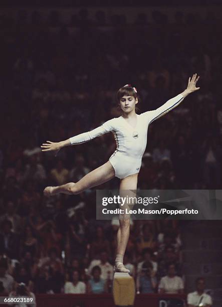 Romanian gymnast Nadia Comaneci, in action during competition on the balance beam, part of the women's artistic team all-around gymnastics...