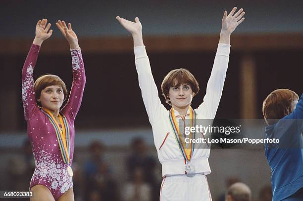 Russian gymnast Yelena Davydova , competing for the Soviet Union, raises her arms in the air on the podium after finishing in first place to win the...