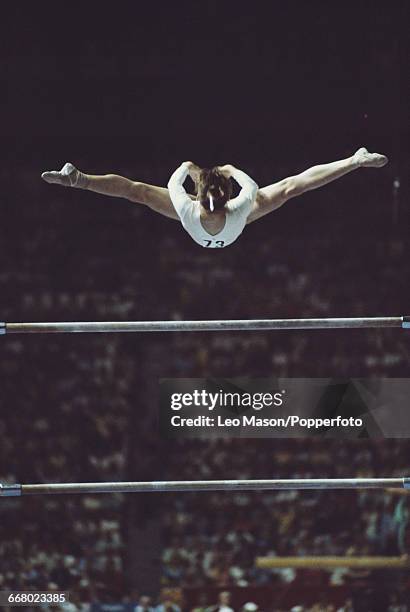 Romanian gymnast Nadia Comaneci, in action during competition on the uneven bars, part of the women's artistic team all-around gymnastics competition...