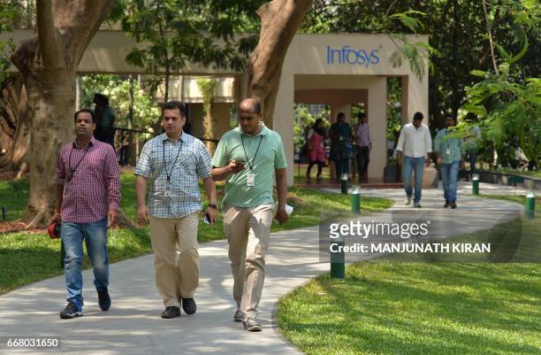 Employees of Infosys Technologies Limited walk in the campus of the company's headquarters in Bangalore on April 13, 2017. Indian software giant...