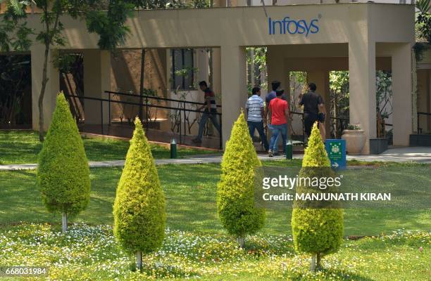 Employees of Infosys Technologies Limited walk in the campus of the company's headquarters in Bangalore on April 13, 2017. Indian software giant...