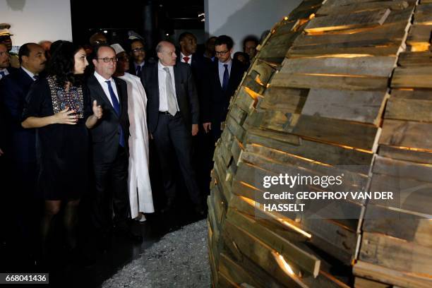 French President Francois Hollande , flanked by French Secretary of State for Development and Francophonie Jean-Marie Le Guen , visits the exhibition...