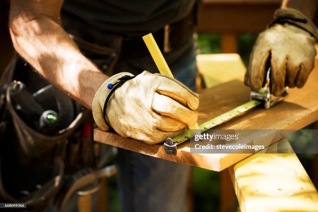 Carpenter Measuring A Wooden Plank.