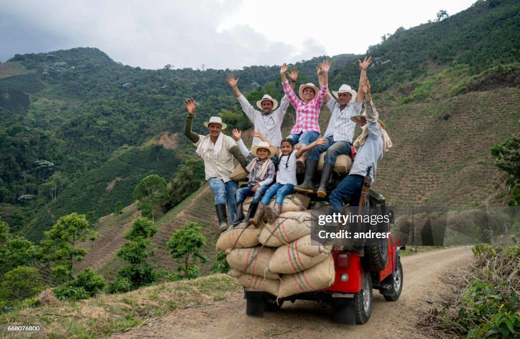 Happy group of farmers transporting coffee on a car
