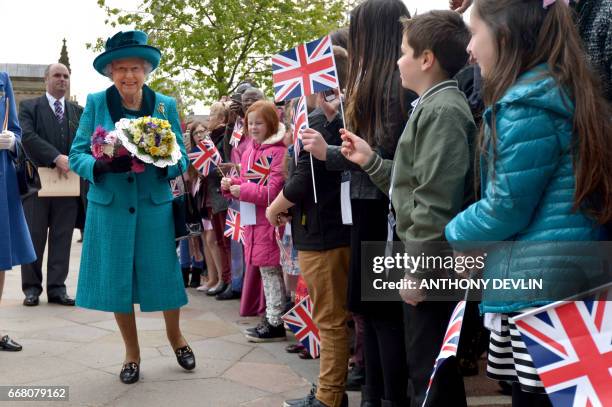 Britain's Queen Elizabeth II meets local children following the Royal Maundy service at Leicester Cathedral on April 13, 2017 in Leicester.