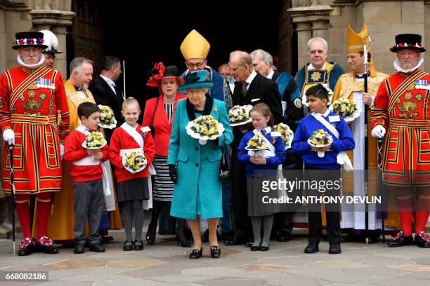 Britain's Queen Elizabeth II and Britain's Prince Philip, Duke of Edinburgh pose with Yeoman of the Guard following the Royal Maundy service at...