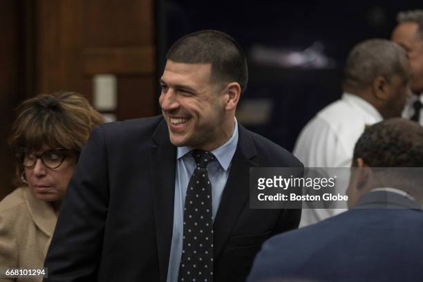 Former New England Patriots tight end Aaron Hernandez smiles at the sight of his fiancées Shayanna Jenkins from the defense table during jury...