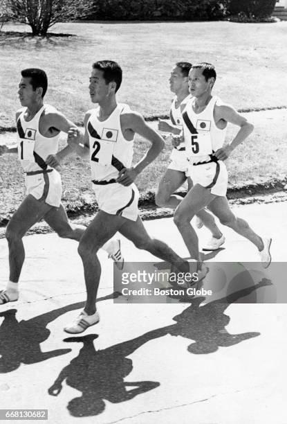 From left, runners Tooru Terasawa, Hirokazu Okabe, Kenji Kimihara and Seiichiro Sasaki, all of Japan, approach Boston College during the 70th Boston...