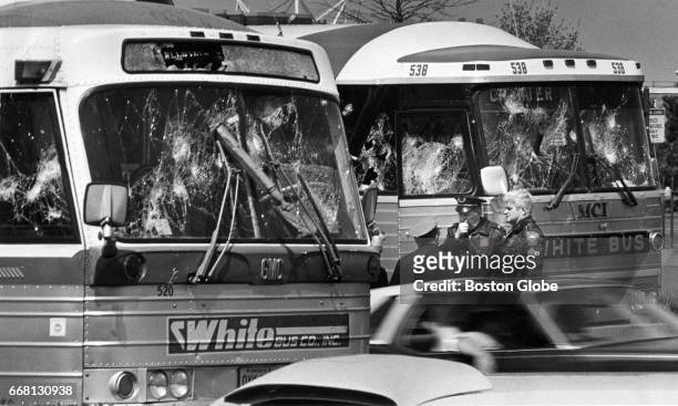 Drivers of two damaged buses speak with police officers on Morrissey Boulevard in Boston on May 3, 1975. The buses were chartered by Progressive...