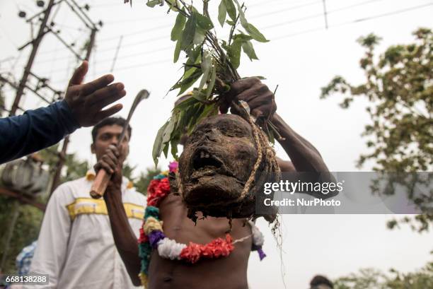 Devotee is holding a human head in his hand in Burdwan, India on 13 April 2017. &quot;Gajan&quot; is one of the prominent folk festivals of Bengal,...