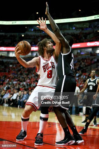 Robin Lopez of the Chicago Bulls attempts a shot while being guarded by Andrew Nicholson of the Brooklyn Nets in the first quarter at United Center...
