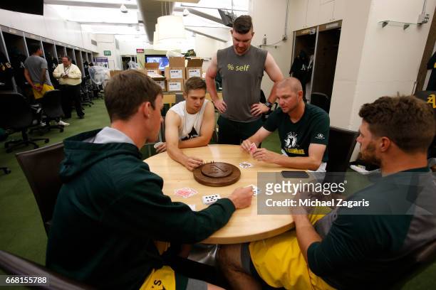 Chris Bassitt, Liam Hendriks, Ryan Madson and Josh Phegley of the Oakland Athletics play canasta in the clubhouse prior to the game against the Los...