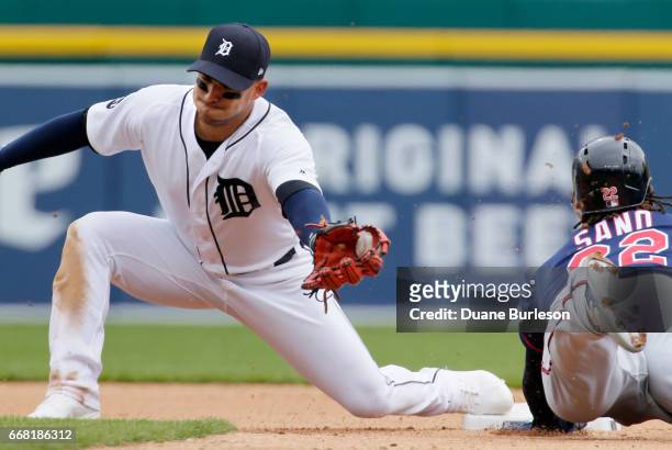 Shortstop Jose Iglesias of the Detroit Tigers stretches to catch the pickoff throw as Miguel Sano of the Minnesota Twins dives into second base on a...