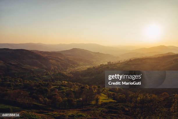 green valley at sunset - resplandeciente stock pictures, royalty-free photos & images