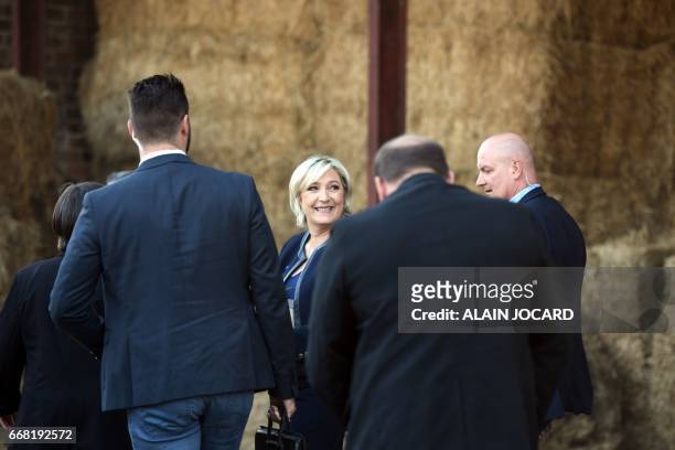 French presidential election candidate for the far-right Front National party Marine Le Pen leaves after delivering a speech, next to her bodyguard...