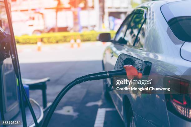 pumping gasoline fuel in car at gas station - working oil pumps stock pictures, royalty-free photos & images