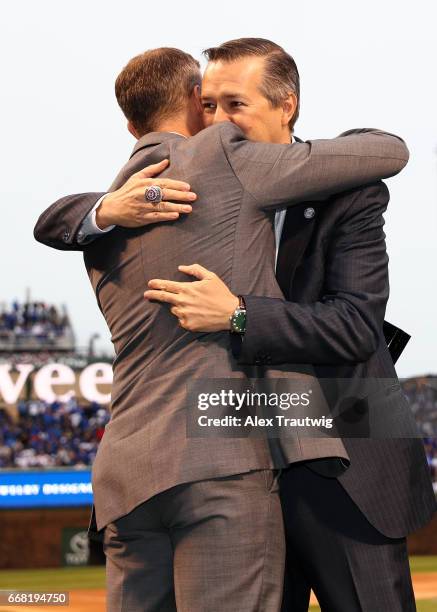 Cubs President of Baseball Operations Theo Epstein hugs owner Tom Ricketts during the World Series ring ceremony ahead of the game between the Los...