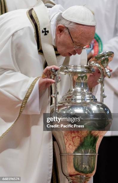 Pope Francis blows in an amphora containing holy oil as he leads the Chrism Mass for Holy Thursday which marks the start of Easter celebrations in...