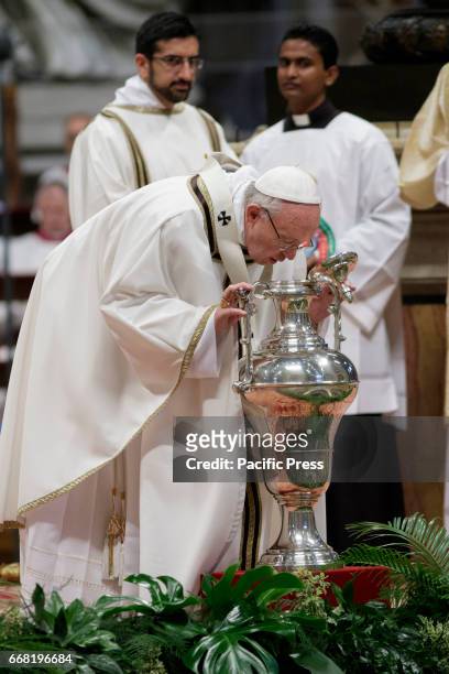 Pope Francis blows in an amphora containing holy oil as he leads the Chrism Mass for Holy Thursday which marks the start of Easter celebrations in...