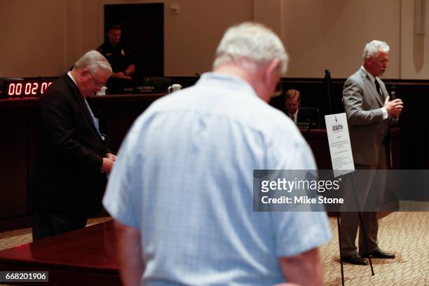Rep. Joe Barton , left, bows his head as his town hall meeting is opened in prayer at Mansfield City Hall on April 13, 2017 in Mansfield, Texas. A...