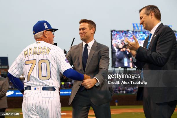 Joe Maddon of the Chicago Cubs is greeted by President of Baseball Operations Theo Epstein and owner Tom Ricketts during the World Series ring...