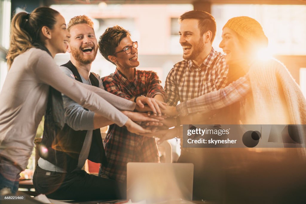 Glücklich Start-up-Team sammelt die Hände in der Einheit.