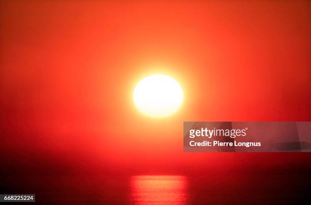 close-up of a red sunset in a the fog above the pacific ocean - fata morgana stock-fotos und bilder