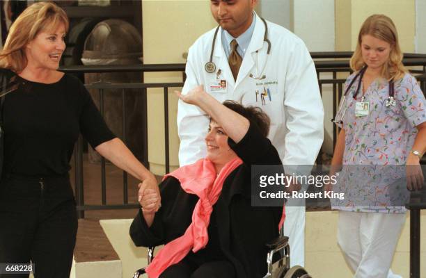 Performer Liza Minnelli holds hands with her half-sister Lorna Luft and waves to well-wishers October 30, 2000 after being released from the...