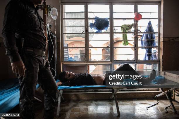 Civilian receives treatment at a field clinic after being shot by an Islamic State sniper in west Mosul on April 13, 2017 in Mosul, Iraq. As the...