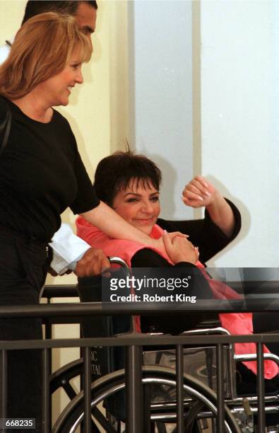 Performer Liza Minnelli is wheeled out of the hospital by her half-sister Lorna Luft October 30, 2000 after being released from the Cleveland Clinic...
