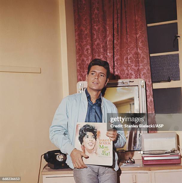 English singer Cliff Richard holding 'More Than The Most', an album by American jazz singer Dakota Staton, circa 1964.