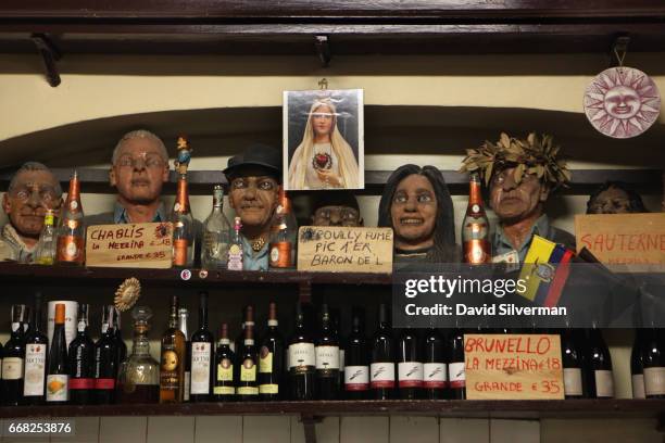 Artwork fills a shelf above bottles of wine in the Osteria Del Sole bar on March 30, 2017 in Bologna, Italy. Situated on Via Ranocchi, an alleyway in...
