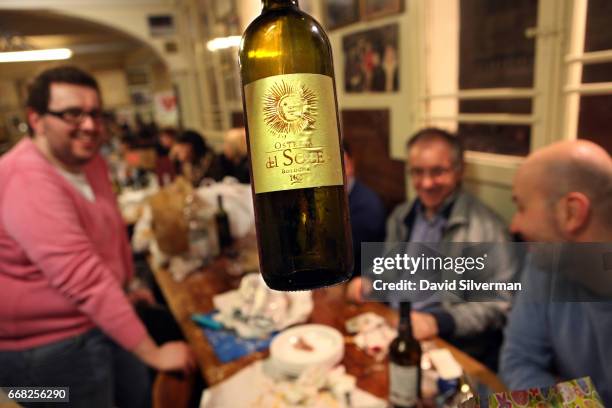 Italian businessmen enjoy a night out together with local white wine bottled especially for the Osteria Del Sole bar on March 30, 2017 in Bologna,...