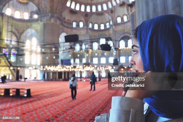 portrait of beautiful muslim woman at prayer in the blue mosque - blue mosque stock pictures, royalty-free photos & images